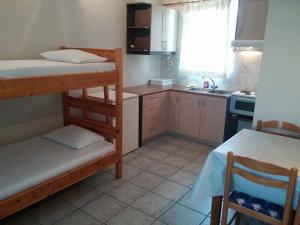 a small kitchen with two bunk beds in a room at Holiday Tolofona Beach in Erateini