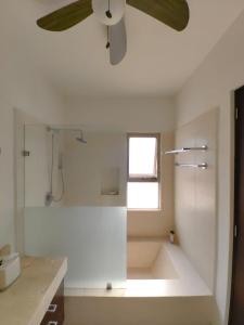 uma casa de banho com uma ventoinha de tecto e um chuveiro em Casa Serena em Cancún