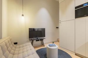 a living room with a couch and a tv at Rio by Wynwood House in Madrid