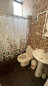 La salle de bains est pourvue de toilettes et d'un lavabo. dans l'établissement Garden House Piura, à Piura