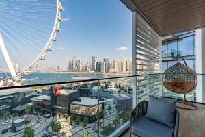 杜拜的住宿－Bluewaters Luxe 3BR with maids room - Panoramic Sea View - CityApartmentStay，阳台享有伦敦眼(london eye)的景致。
