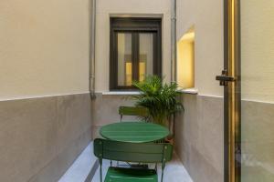 a green table and two chairs in a building at Rio by Wynwood House in Madrid