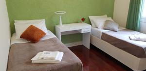 um quarto com duas camas e uma mesa de cabeceira com uma cama sidx sidx em SP Guest House em São Paulo