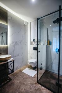 e bagno con servizi igienici e doccia in vetro. di Sunshine apartments - Valjevo a Valjevo