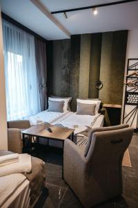瓦列沃的住宿－Sunshine apartments - Valjevo，一间设有两张床和一张桌子及椅子的房间