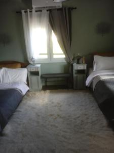 een slaapkamer met 2 bedden en een raam bij Traditional villa KALAMPAKA 