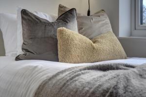 a bed with pillows and a blanket on it at Kist Accommodates presents - Hygge House in Ripon