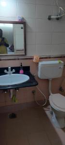 a bathroom with a sink and a toilet and a mirror at Service Apartment Near Rameshwaram Cafe Brookefield in Bangalore