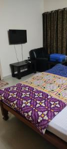 a bed with a colorful quilt on it in a room at Service Apartment Near Rameshwaram Cafe Brookefield in Bangalore
