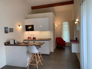cocina con armarios blancos, mesa y sillas en Au Coeur de la Provence, en Éguilles