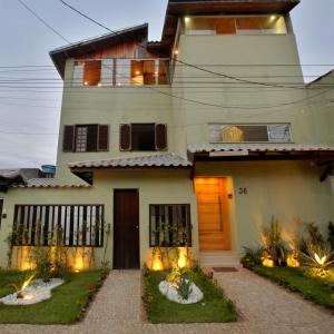 a house with a front yard with a driveway at Recanto Novo Premium Flat in Cabo Frio