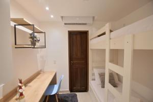 a room with a desk and a bunk bed at Recanto Novo Premium Flat in Cabo Frio