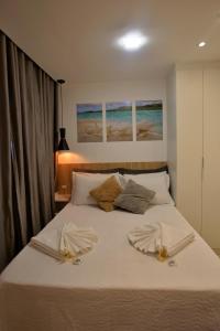 a bedroom with a bed with two towels on it at Recanto Novo Premium Flat in Cabo Frio