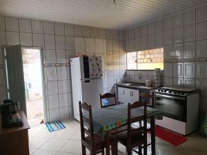 uma cozinha com uma mesa e um frigorífico branco em Casa Temporada Prado-BA em Prado