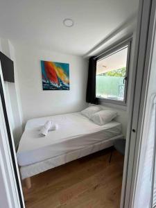 ein kleines Bett in einem kleinen Zimmer mit Fenster in der Unterkunft Superbe appartement, terrasse, accès direct RER in Massy