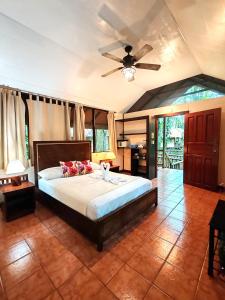 - une chambre avec un lit et un ventilateur de plafond dans l'établissement Evergreen Lodge, à Tortuguero