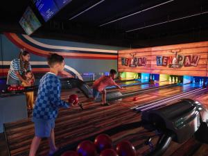 um grupo de pessoas jogando boliche em uma pista de boliche em Great Wolf Lodge Colorado Springs em Colorado Springs