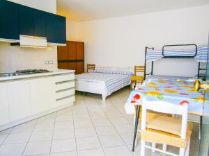 een keuken met een tafel en een bed in een kamer bij Residence Mediterraneo - Agenzia Cocal in Caorle