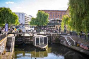 ein Fluss mit einem Boot in einer Stadt in der Unterkunft Camden Loft Apartment! in London