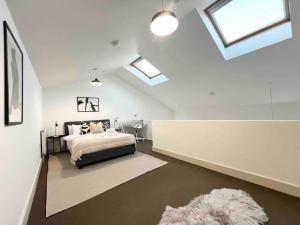ein Schlafzimmer mit einem Bett in einem Zimmer mit Oberlichtern in der Unterkunft Camden Loft Apartment! in London