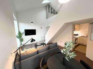 ein Wohnzimmer mit einem Sofa und einem Tisch in der Unterkunft Camden Loft Apartment! in London