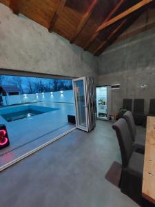 a large living room with a swimming pool and a large window at Romantic Lodge in Banja Luka