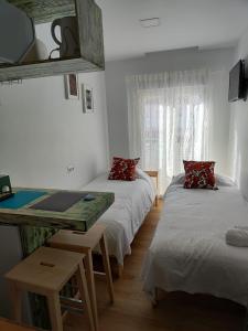 een kamer met 2 bedden, een bureau en een tafel bij KHORS in Málaga