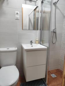 een badkamer met een toilet, een wastafel en een spiegel bij KHORS in Málaga