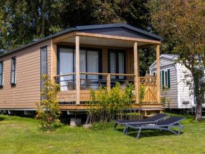 una casa pequeña con terraza y mesa en Wadden Lodge Living, en Westerland