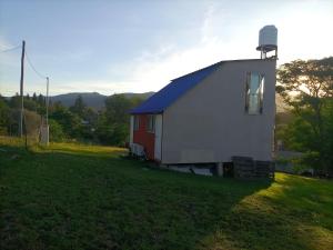 a small white building on a grass field at Cabañas Guayacán in Bialet Massé