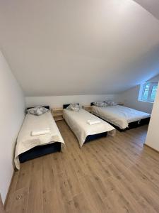 a room with two beds and a wooden floor at Radikiai House 