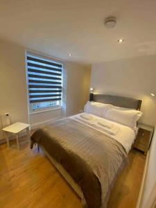 Un dormitorio con una cama grande y una ventana en The Suite Apartment @3 en Barnsley