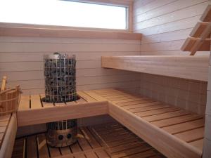 a sauna with wooden shelves and a window at Sunrise View Lapland, Sky View Bedroom & Hot Tub in Kilpisjärvi