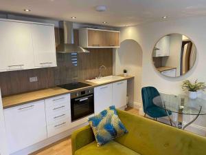 a kitchen with a green couch and a glass table at The Suite Apartment @3 in Barnsley