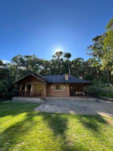 a house with a large driveway in front of it at Encanto Chalé in Monte Verde +98 photos