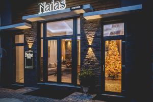 uma frente de loja com portas de vidro e uma árvore de Natal em Naias Nemeia Luxury Rooms em Neméa
