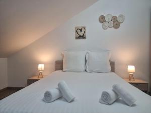a bedroom with a white bed with two towels on it at Le Ruisseau à Bussang Htes Vosges tout confort in Bussang