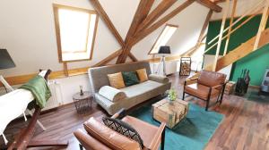 an attic living room with a couch and chairs at Green Loft Schwarzwald - 120qm - Dach-Balkon in Winzeln