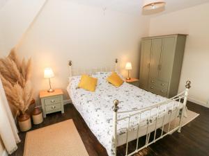 sypialnia z białym łóżkiem z żółtymi poduszkami w obiekcie Kenfig Farm w mieście Bridgend
