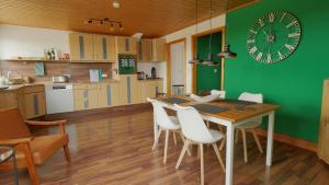 a kitchen with a dining table and a green wall at Green Loft Schwarzwald - 120qm - Dach-Balkon in Winzeln