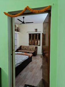 een open deur naar een slaapkamer met een bed en een bank bij JPM Hostel in Varanasi
