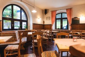 un restaurante con mesas, sillas y ventanas en Gasthof und Pension Hammerschänke, en Wildenthal