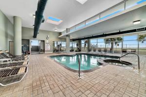 - une grande piscine dans un bâtiment avec des chaises dans l'établissement Tidewater 401, à Orange Beach