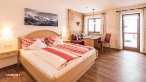 a bedroom with a large bed with a desk and a table at Gschwenderhaus Ferienwohnungen in Oberstdorf