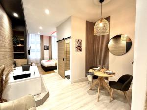 a living room with a couch and a table at Suite Cosy Jacuzzi Troyes - Secrets d'Ana in Troyes