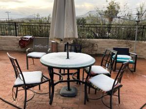 einen Tisch und Stühle mit Sonnenschirm auf einer Terrasse in der Unterkunft Desert retreat close to downtown/ U of A, 1-10 in Tucson