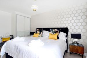 a bedroom with a large white bed with yellow pillows at Farnborough central in Farnborough