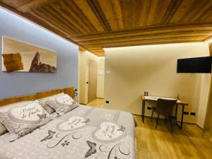 a bedroom with a bed and a desk and a television at Bed and Breakfast Soffio di Vento in Pont-Saint-Martin
