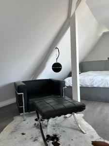 einen schwarzen Stuhl in einem Zimmer mit einem Bett in der Unterkunft Rooftop Living inkl Homeoffice bis 4 Personen in Friedrichshafen