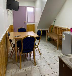 a dining room with a table and chairs and a kitchen at Departamentos k&m in Puerto Natales